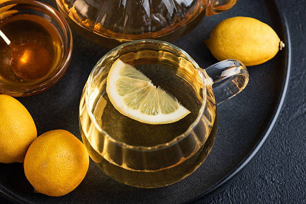 Amber seasonal herbal tea in a glass teapot with lemon slice