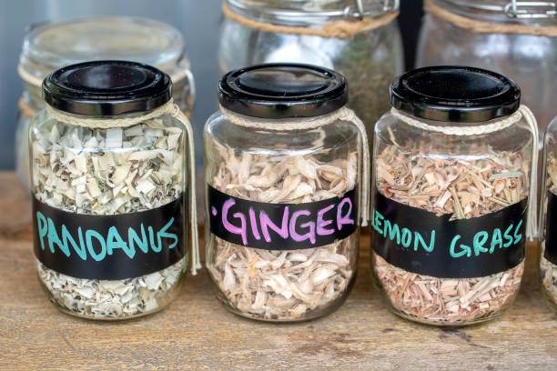 Labelled glass jars of dried herbs on a kitchen shelf