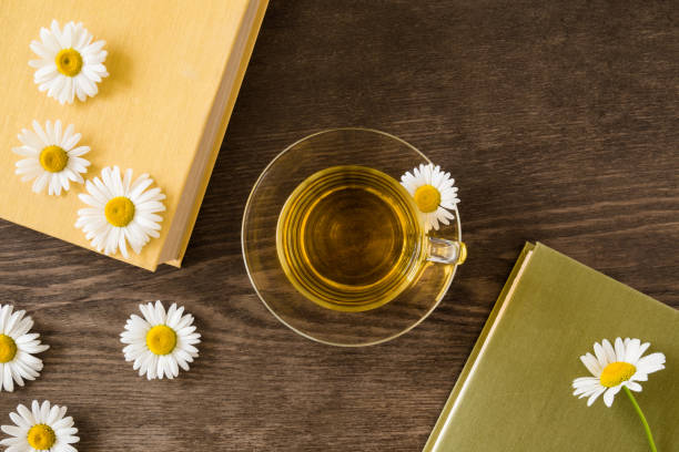 Steaming cup of chamomile tea beside an open book